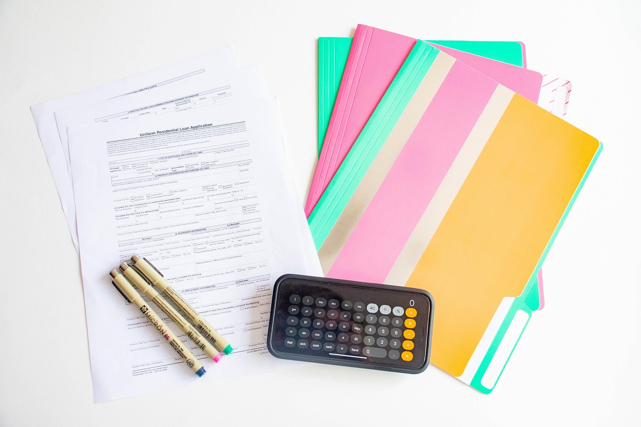 Calculator, paperwork, and office folders for Texas real estate exam math practice